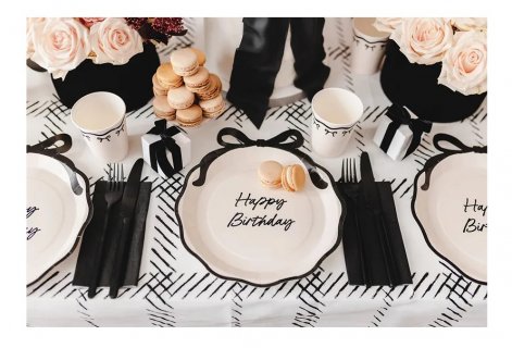 Large plates in creme color with a black bow design for a birthday theme party