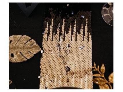 A glamorous table runner with sequins in black, gold and silver color