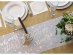 White fabric runner with gold and silver details for the New Years Eve table decoration